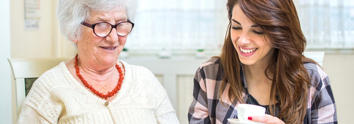 Grandmother and granddaughter looking at photo album together.